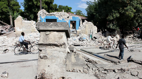 Des Haïtiens matchent dans les ruines de maisons détruites de Léogâne le 16 janvier 2009.