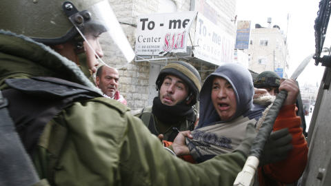 Des soldats israéliens tentent d'immobiliser des manifestants palestiniens.