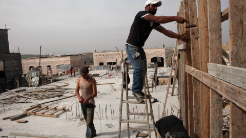 Des ouvriers palestiniens construisent des maisons dans la colonie juive de Jérusalem-Est Ramat Shlomo.