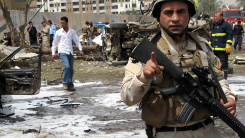 Des secouristes et des policiers inspectent la scène d'un attentat près de l'ambassade d'Iran, au centre de Bagdad, le 4 avril 2010.