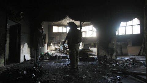 Des soldats israéliens inspectent la mosquée incendiée.