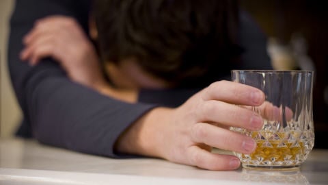 Une personne avec un verre d'alcool