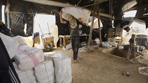 Un Palestinien transporte des sacs qui ont transité par des tunnels creusés sous la frontière avec l'Égypte. Les Palestiniens utilisent ces tunnels pour contourner le blocus.