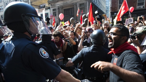 Les policiers repoussant les manifestants à Toronto.