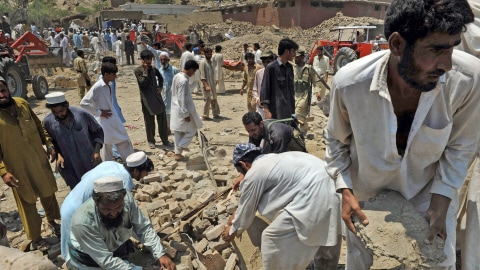 Des Pakistains cherchent des victimes sous les décombres.