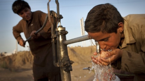 Un jeune Pakistanais boit de l'eau dans un quartier pauvre situé à la périphérie d'Islamabad.