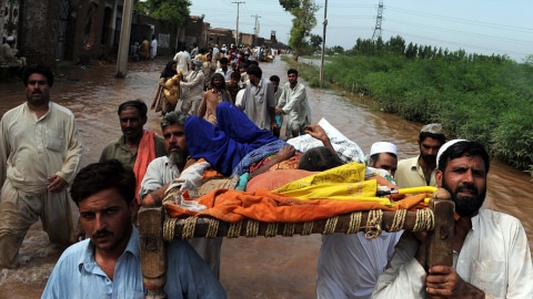Un groupe transporte une femme malade en évacuant un village de la région de Mohib Bhanda, au nord-ouest du Pakistan.