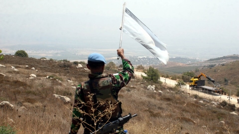 Un soldat de la FINUL agite le drapeau de l'ONU en direction de soldats israéliens avant les affrontements.