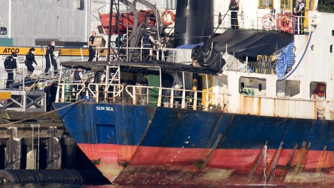 Des policiers et des militaires, portant des masques sanitaires, montent à bord du MV Sun Sea, le 13 août 2010.