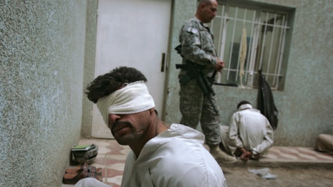 Un soldat américain surveille des détenus irakiens.