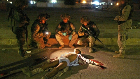 Des militaires américains autour du corps d'un Irakien à Bagdad à Tikrit, en 2003
