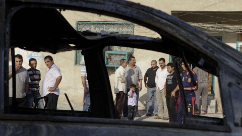 Des chrétiens de Bagdad, vus à travers une voiture qui a explosé mercredi.