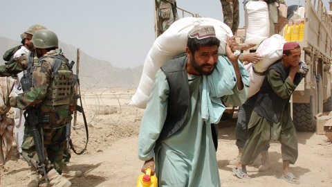 Des Afghans déchargent une cargaison de céréale dans la ville de Khenjakak.