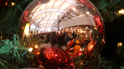 À l'aéroport de Düsseldorf, en Allemagne, plusieurs passagers, reflétés dans des décorations de Noël, ont vu leurs plans du réveillon perturbés.