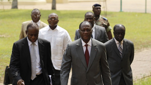 Alassane Ouattara (à l'avant-plan, avec la cravate rouge), entouré de sa garde rapprochée, sur le terrain de l'Hôtel du Golf, à Abidjan.