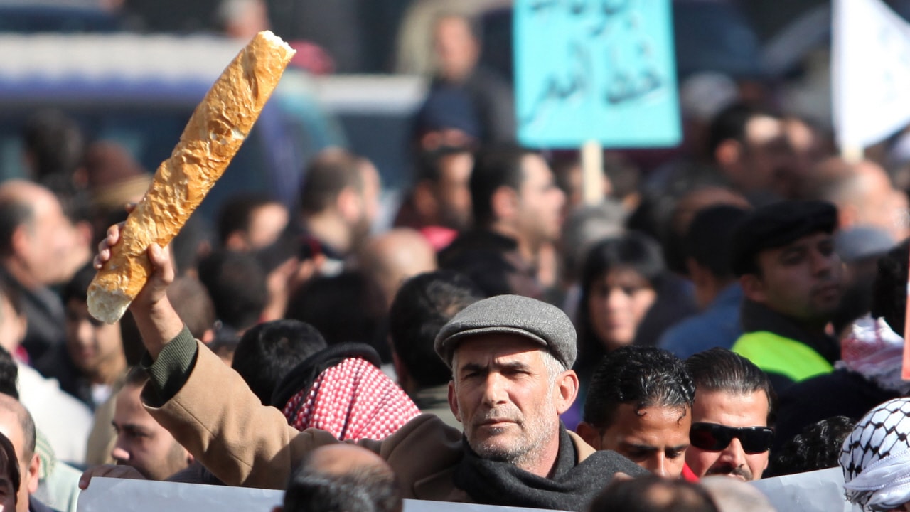 Un homme brandit un pain lors d'une manifestation à Amman, le 14 janvier 2011.