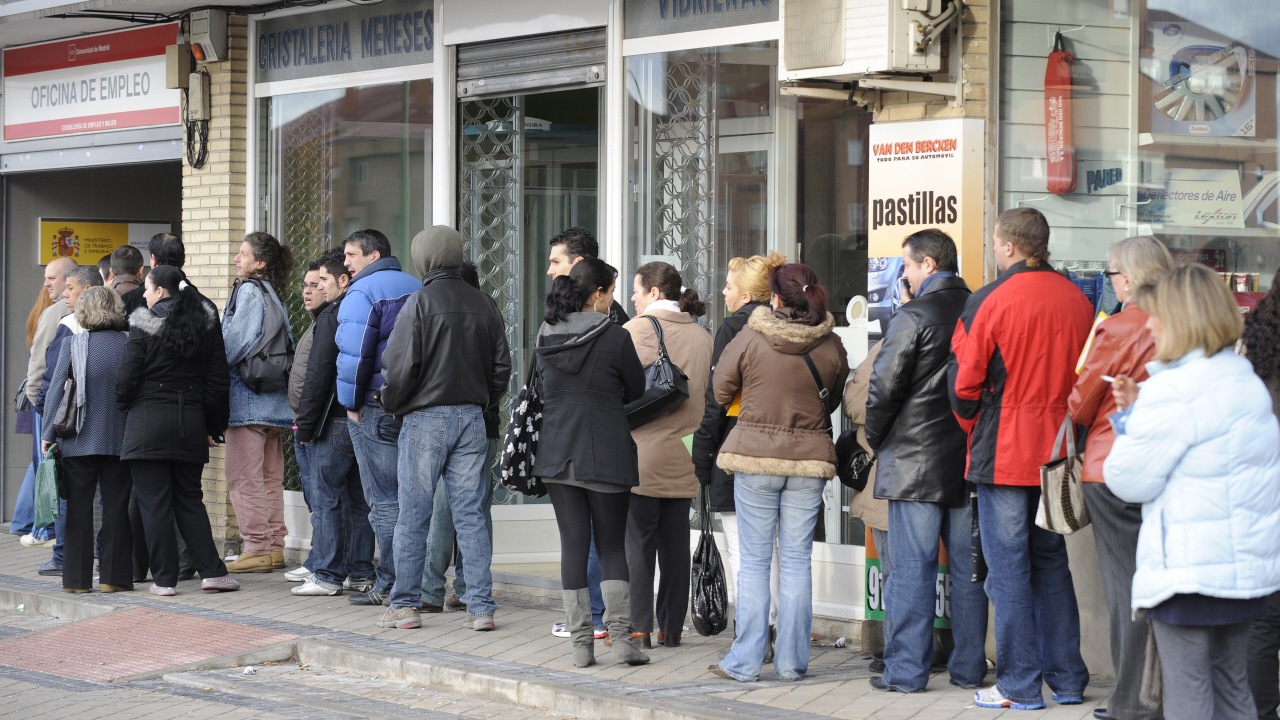 À Madrid en Espagne, des travailleurs attendent devant un bureau de chômage.