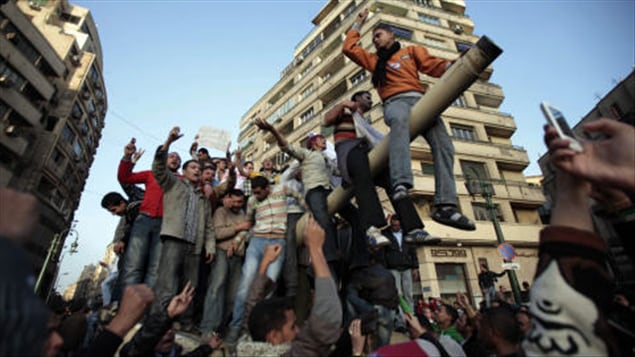 Des manifestants sur un char d'assaut au Caire.