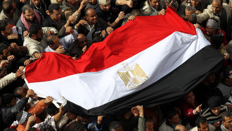 Des manifestants rassemblés au Caire tiennent un drapeau égyptien