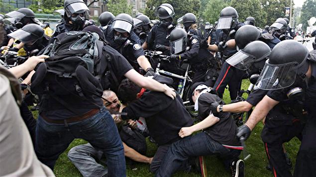 Des policiers tentent de maîtriser des protestataires le 26 juin.