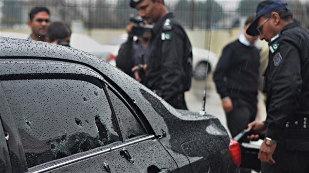 Des policiers inspectent la voiture criblée de balles du ministre des Minorités religieuses, Shahbaz Bhatti.