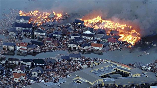 Les flammes et les flots s'affrontent de façon saisissante à Natori, dans la préfecturede Miyagi.