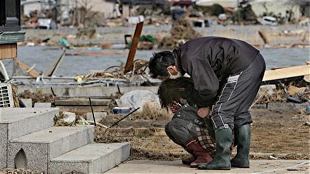 Une femme pleure devant sa maison détruite dans la ville de Watari