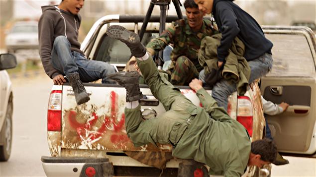 Un rebelle libyen chute d'un camion fuyant Ajdabiya.