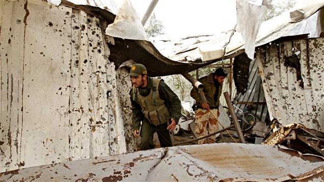 Des policiers du Hamas constatent les dégats provoqués par un raid israélien.