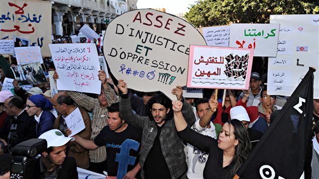 Des manifestants tiennent des pancartes en arabe et en français, réclamant plus de justice au Maroc
