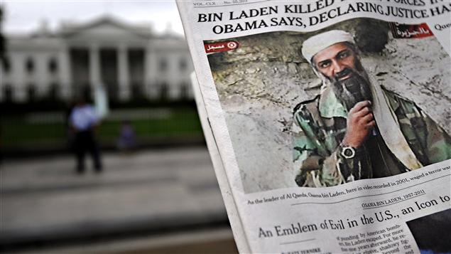 Près de la Maison-Blanche, un homme lisant un journal annonçant la mort de Ben Laden