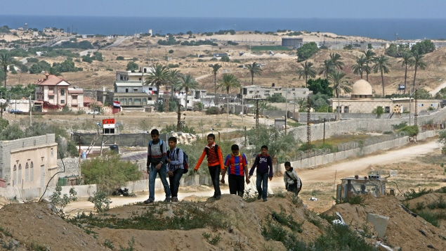 Des jeunes marchent près du point de passage de Rafah, dont l'ouverture imminente a été annoncée récemment par le gouvernement égyptien.