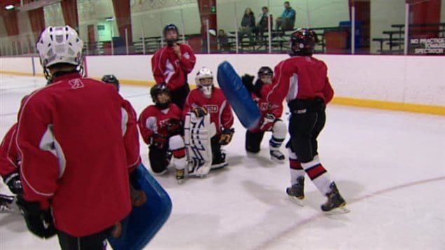 Des jeunes hockeyeurs albertains s'entraînent à faire des mises en échec.