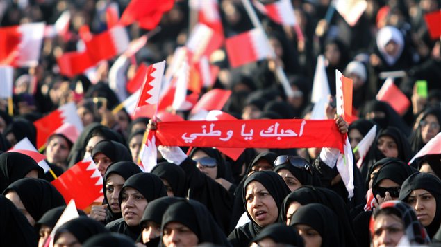 Une femme porte une banderole disant « J'aime mon pays » lors d'une manifestation organisée par le groupe d'opposition Al-Wefaq à Sitra, à Bahreïn.