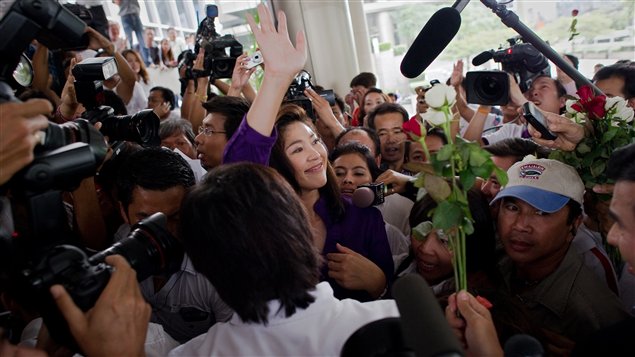 Yingluck Shinawatra salue les médias à son arrivée au quartier général de son parti, à Bangkok.