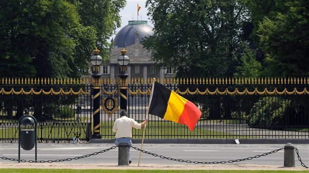 Un homme tient le drapeau belge devant le palais royal, en juin 2010, quatre jours après les élections qui ont plongé le pays dans une crise politique prolongée.
