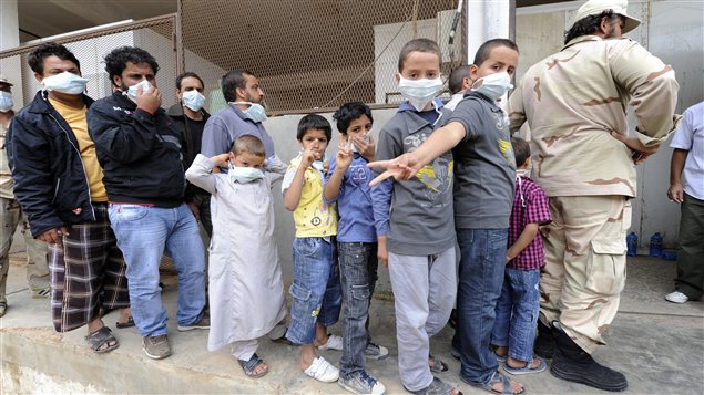 Hommes et enfants font la queue devant un entrepôt frigorifique de Misrata pour apercevoir le cadavre de Mouammar Kadhafi