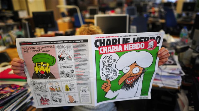 Une personne lit l’édition controversée de Charlie Hebdo.