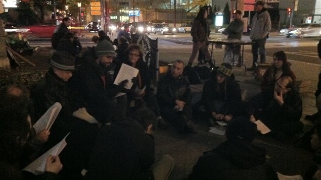 Des occupants du square Victoria discutaient d'un document expliquant les raisons de leur indignation, mardi soir.