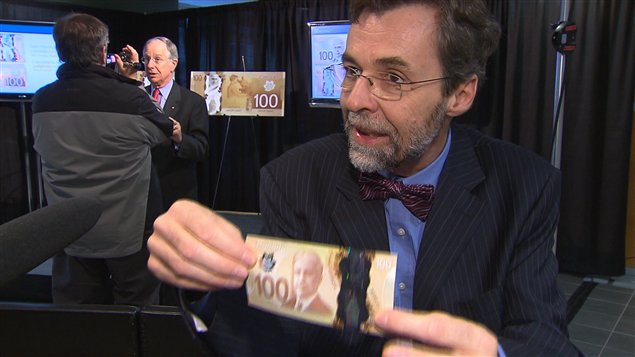 Michel Lebeau, analyste sénior à la Banque du Canada, tient un nouveau billet de 100 $.