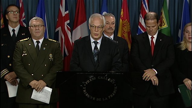Le ministre québécois Robert Dutil (au centre) et des représentants de corps policiers et de groupes de défense du registre.