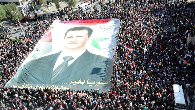 Des manifestants autour d,un portait géant de Bachar Al-Assad.