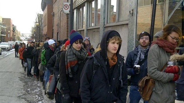 Des étudiants en art de l'UQAM attendent en file devant Le National sur la rue Ste-Catherine à Montréal pour voter à l'assemblée général de déclenchement de grève.
