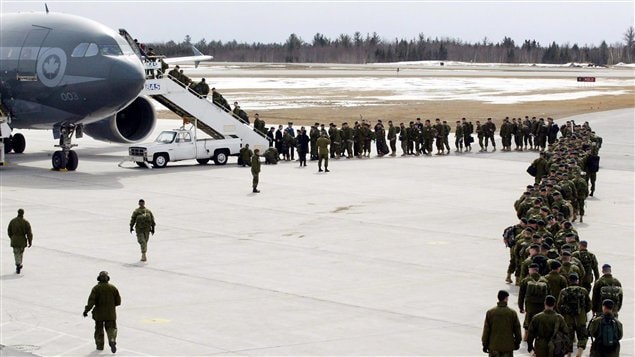 Des soldats montent à bord d’un avion à la base militaire de Gagetown, en 2004.