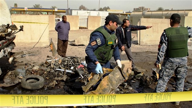 Les forces de sécurité irakiennes collectent des débris après un attentat survenu le 23 février dans l'ouest de Bagdad