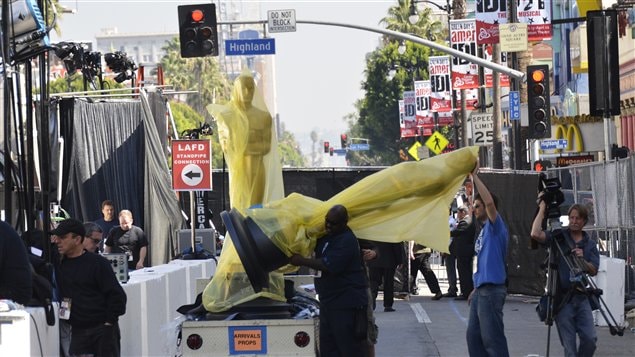 Des travailleurs installent un Oscar géant sur le tapis rouge où défileront les stars du cinéma ce soir.