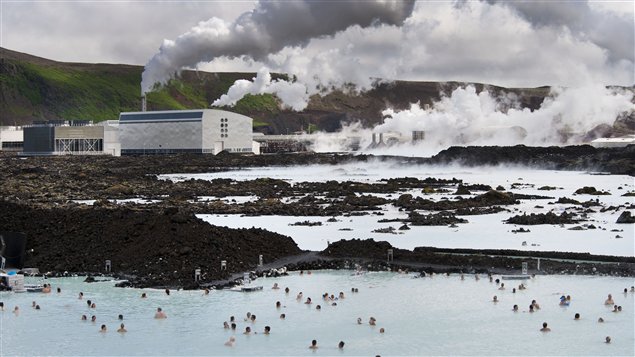 Des touristes dans le Blue Lagoon à Svartsendi à côté d'une centrale électrique.