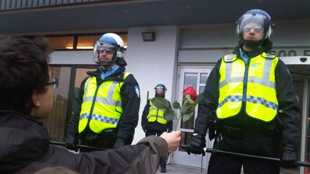 Un étudiant tend une rose à un policier devant le ministère de l'Éducation