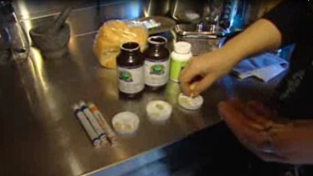 Une mère prépare les doses de vitamines pour sa famille.