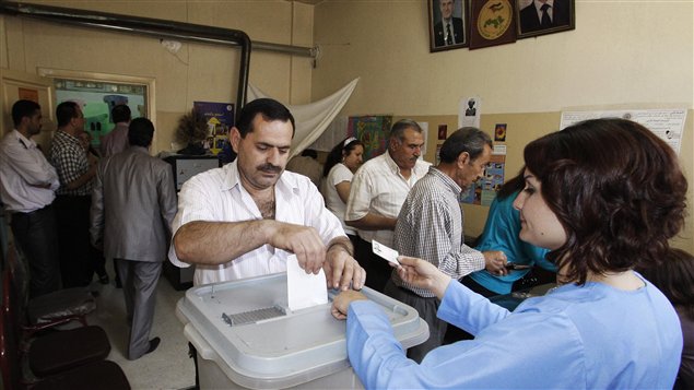 Un homme dans un bureau de vote à Damas, dans le cadre des élections législatives syriennes.